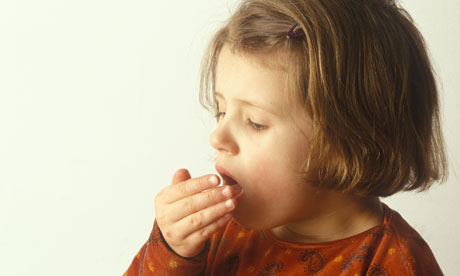 little girl coughing with hand over her mouth